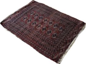 A Bokara Tekke rug with two rows of elephant foot guls on a red ground, 147cm x 103cm approximately