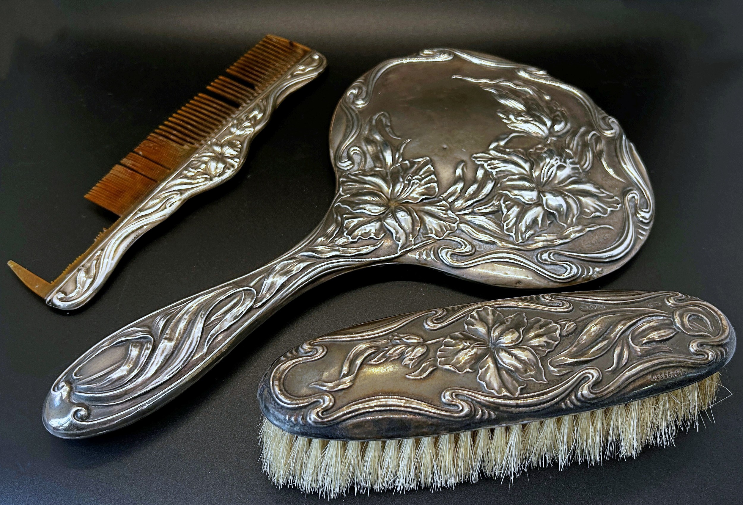 A silver Art Nouveau hand mirror with all over floral pattern, Chester 1909, maker J & R Griffin,