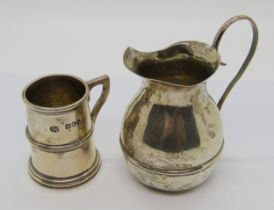 A lightly hammered silver cream jug, Birmingham 1927, maker Albert Edward Jones, together with a