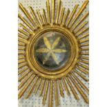 A 19th century carved gilt-wood wall-hanging ecclesiastical starburst roundel, with central star