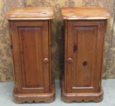 A pair of bedside cabinets in pine with panelled doors