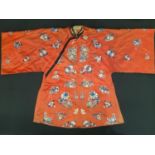 A late 19th/ early 20th century Chinese robe of red silk embroidered with flowers, moths and other