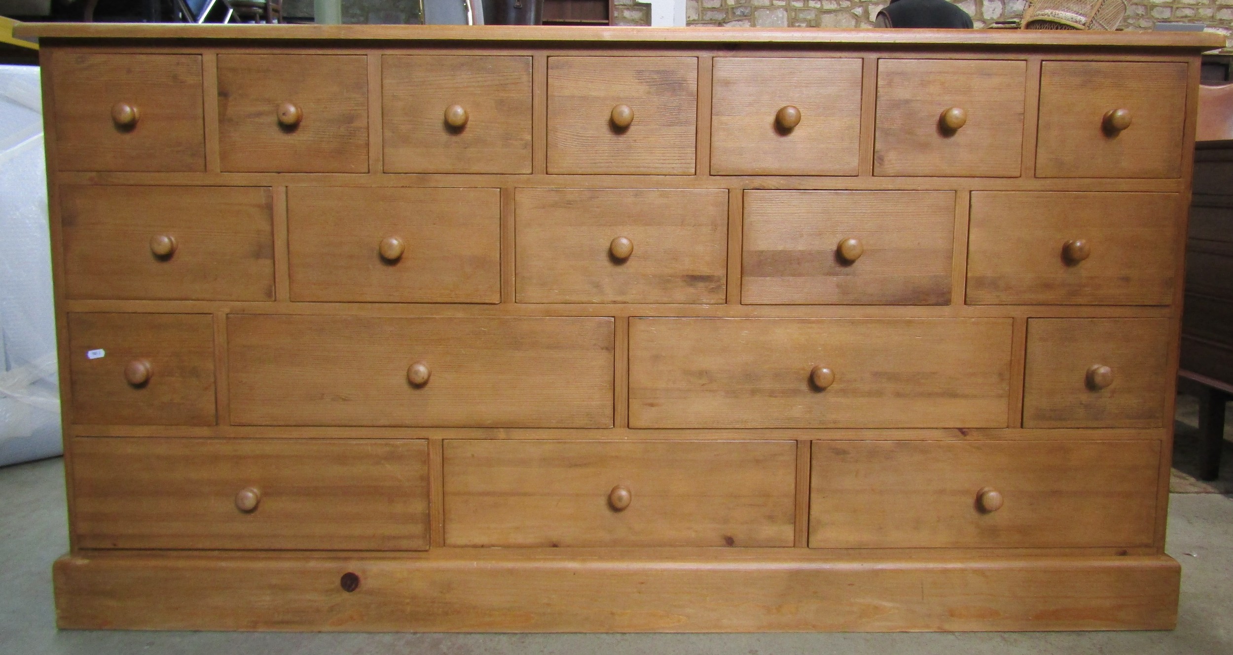 A traditional pine cabinet containing a series of 19 drawers, 180cm long x 93cm high x 48cm deep