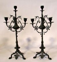 A tall pair of 19th century bronze five light candelabra, with ebonised finish, scrolling and
