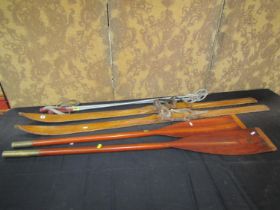 A pair of vintage ashwood skis, sticks, together with a pair of timber oars