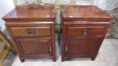 A pair of Chinese hardwood side cabinets each enclosed by a drawer and door, 61cm high