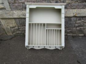 A contemporary wall mounted plate rack with several divisions and central shelf, within a painted