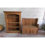 A stripped and waxed pine settle with rising lid, the panelled back within a shaped outline, 93cm