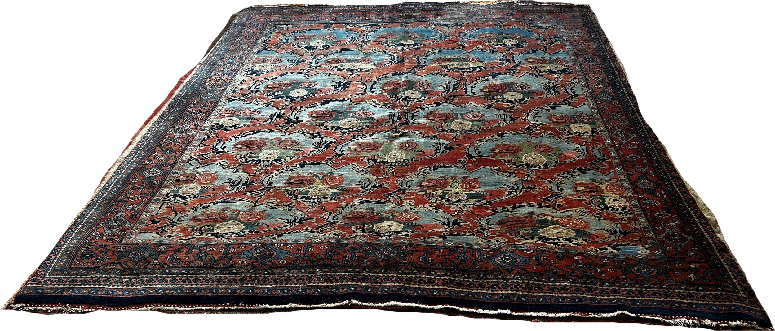An Old Persian carpet with a repeating floral pattern on a pink ground, one corner badly worn with - Bild 2 aus 3