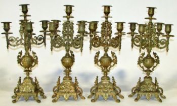 A set of four cast brass five light candelabra, each with scrolled branches and twin-handled urn