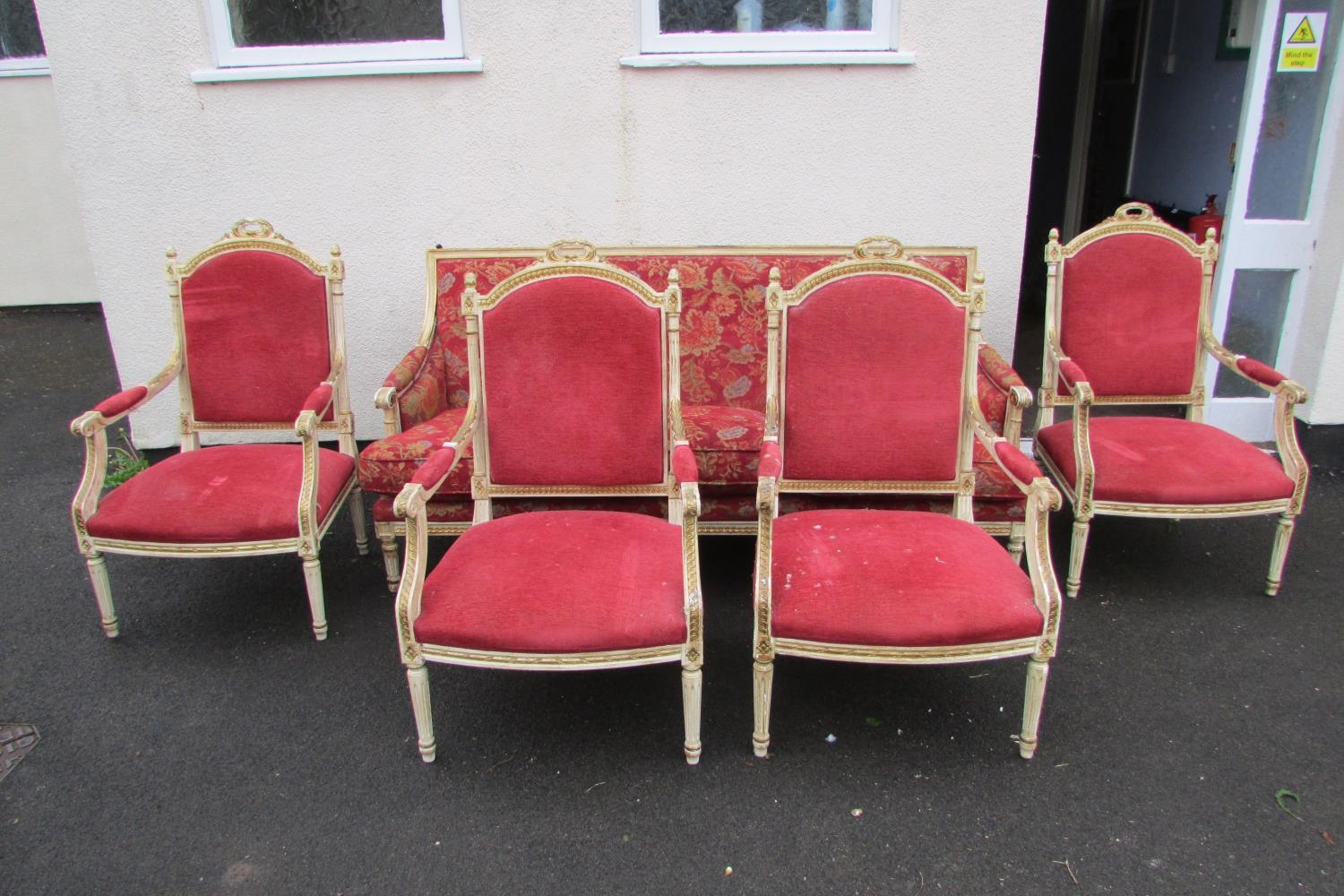 A French drawing room suite comprising a three seat sofa and four matching tub chairs, the frames