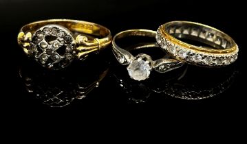 Three colourless stone rings comprising an 18ct bi-colour eternity ring, 4.3g, an antique 9ct X