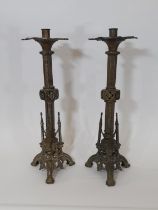 A pair of 19th century gothic ecclesiastical brass candlesticks, with flared cradles over pierced