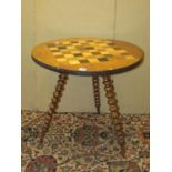 A 19th century chequerboard games table, in mixed woods, raised on three bobbin supports, 62cm