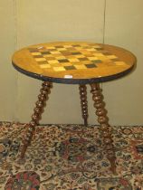 A 19th century chequerboard games table, in mixed woods, raised on three bobbin supports, 62cm