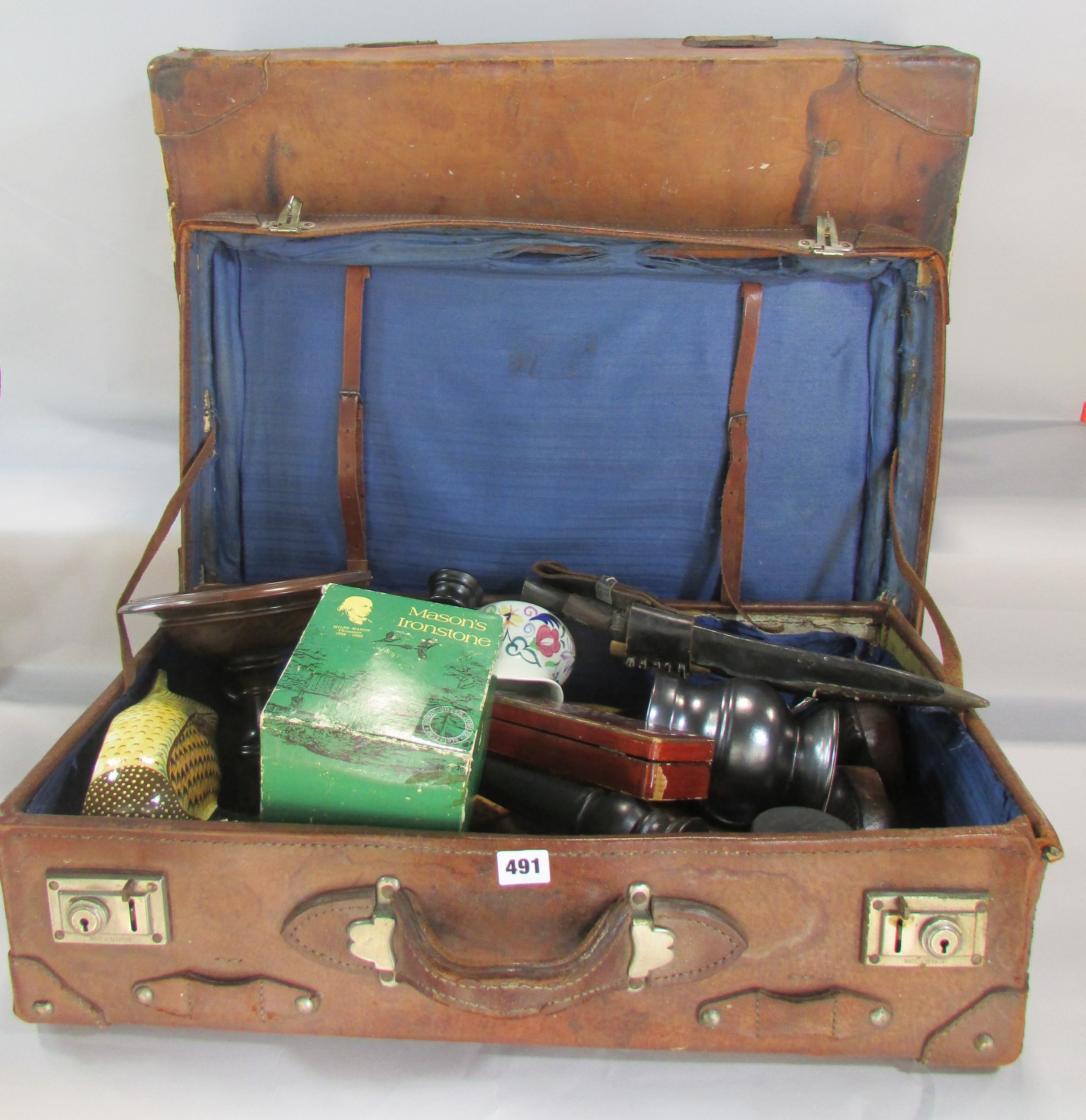 Two vintage battered leather suitcases, containing a miscellaneous collection of items including two