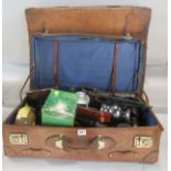 Two vintage battered leather suitcases, containing a miscellaneous collection of items including two