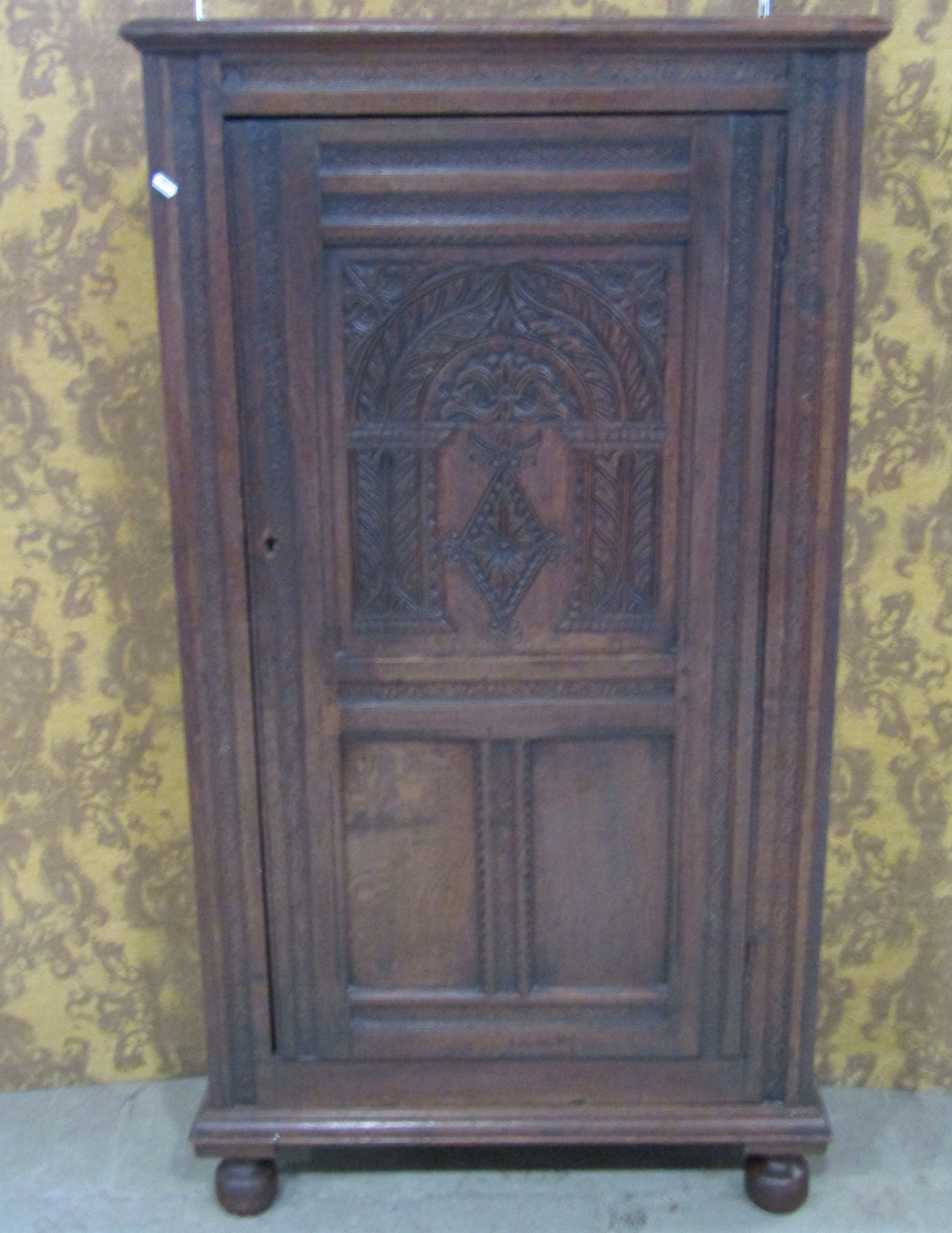 An old English style carved oak side cupboard in the Elizabethan style with panelled framework and
