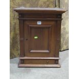 A small late Victorian mahogany hanging wall cupboard enclosed by a rectangular panelled over a