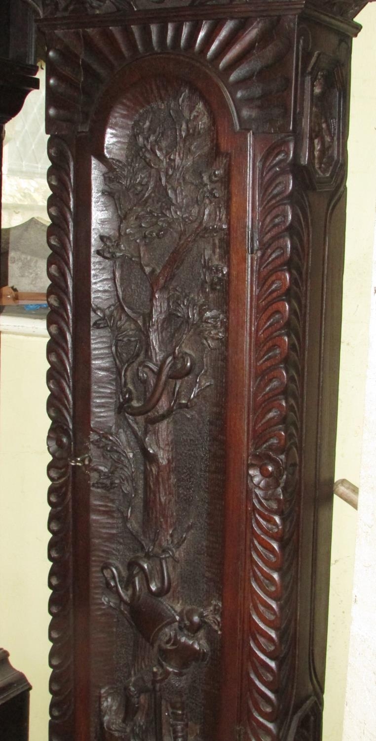 A 19th century oak longcase clock with heavy estate carving, the trunk detailing a knight fighting - Image 7 of 17