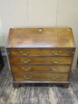 A Georgian mahogany bureau of four long drawers, the fall flap enclosing a fitted interior of