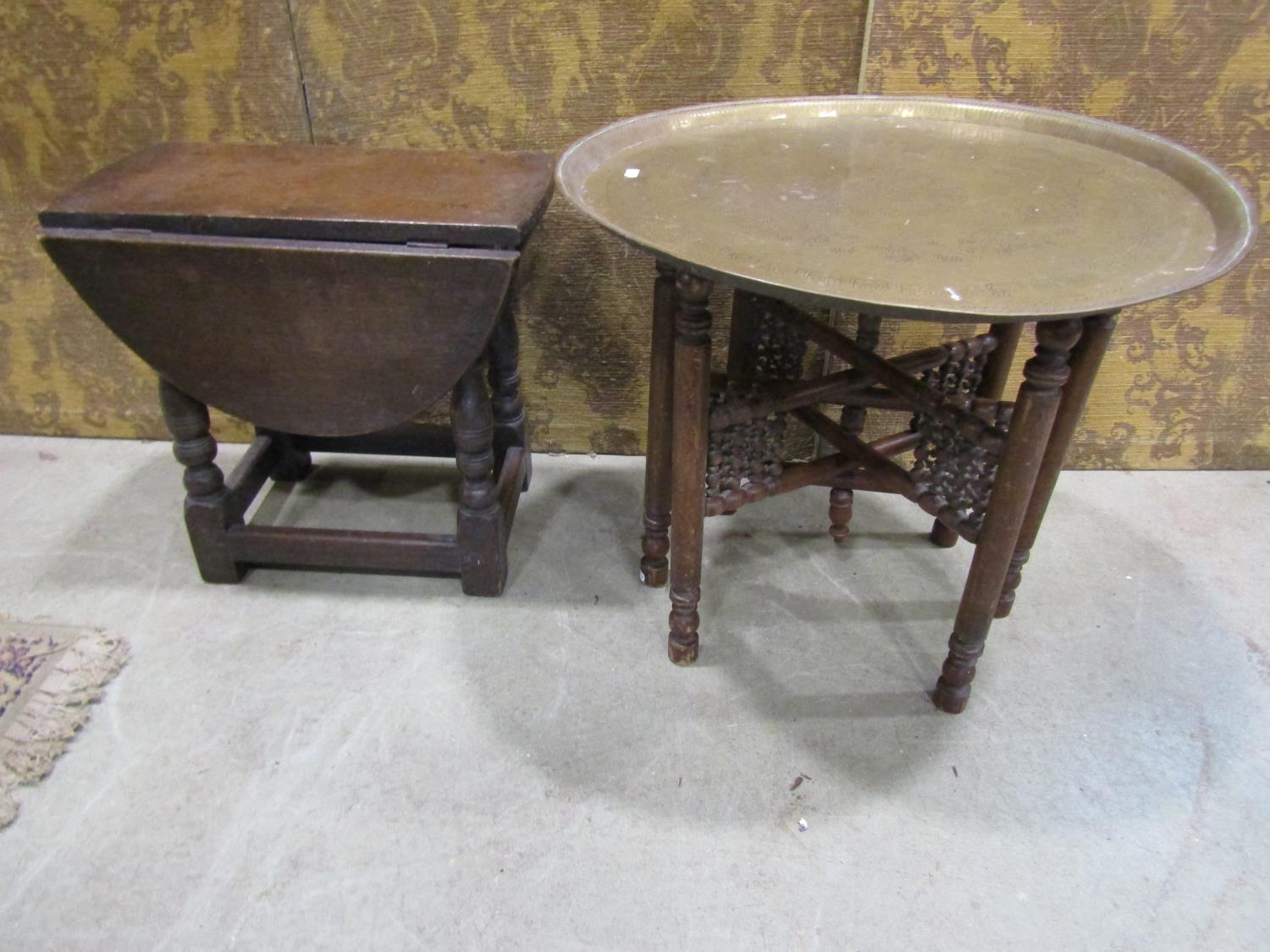 An old English oak drop leaf occasional table together with an Indian brass tray top table with