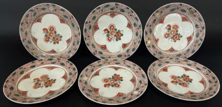 Six Japanese porcelain plates with chrysanthemum detail within repeating scaled borders, 22 cm
