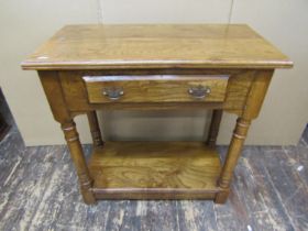 A good quality Georgian style side table in elm, with frieze drawer raised on four gun barrel