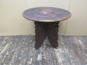 An Anglo Indian carved occasional table with circular top on a tripod base, with repeating vine leaf