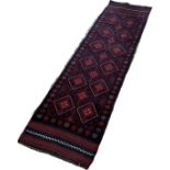 A Meswani runner with a red and blue all over diamond pattern 229 x 60 approximately
