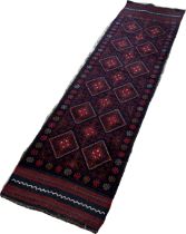 A Meswani runner with a red and blue all over diamond pattern 229 x 60 approximately