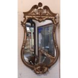 A 19th century French wall mirror of waisted form with painted and gilded detail, beneath a swan