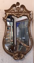 A 19th century French wall mirror of waisted form with painted and gilded detail, beneath a swan