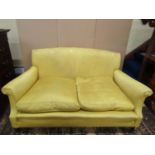 A Howard & Son two seat sofa with scrolled arms raised on square taper legs with brass cup