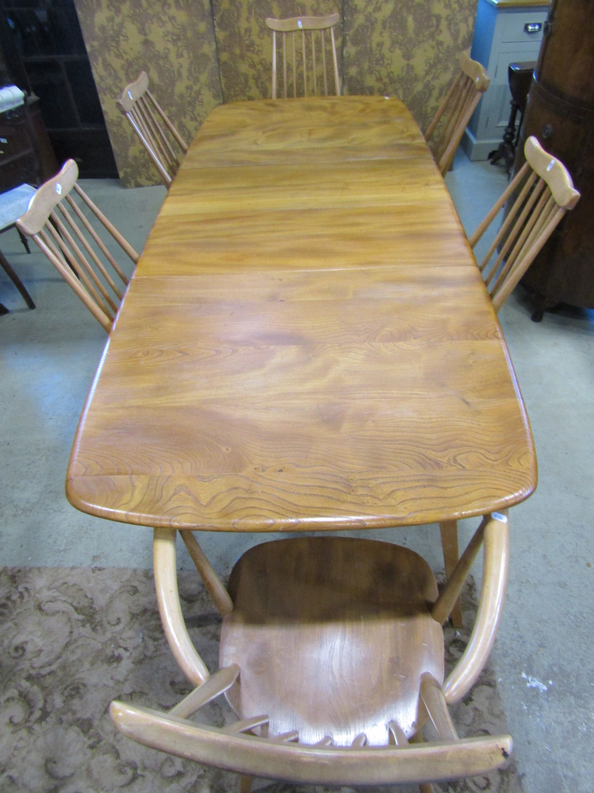An Ercol extending dining table with additional folding leaf, elm table on square cut splayed