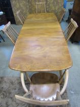 An Ercol extending dining table with additional folding leaf, elm table on square cut splayed