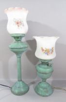 Two oil lamps with a painted green wash finish converted to electric lamps, both with glass shades.