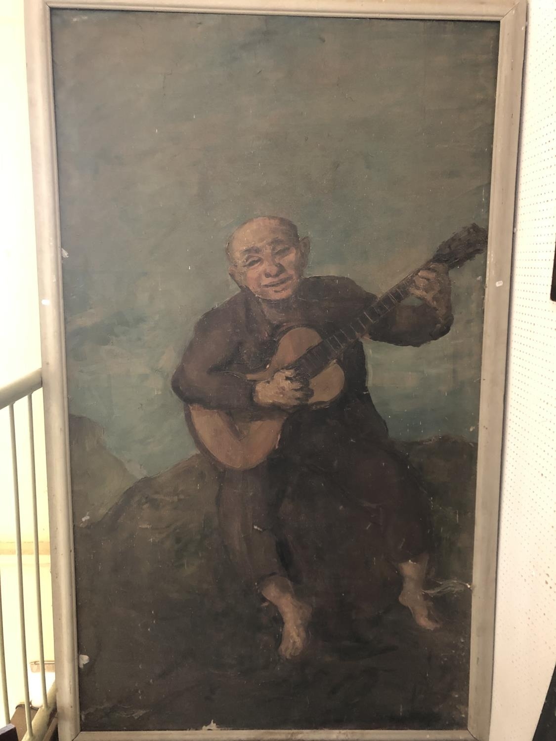 An very large genre painting depicting a seated musician playing the guitar, early 20th century, oil