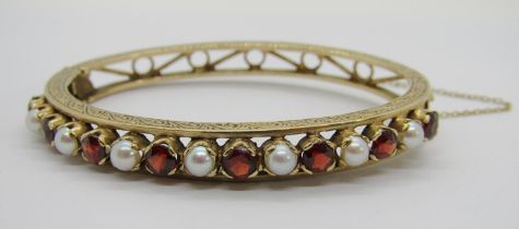 Vintage yellow metal hinged bangle set with eight garnets and seven pearls, with engraved scrolled