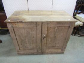 A stripped pine side cupboard enclosed by two doors