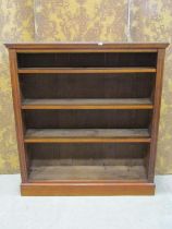A late 19th century walnut bookcase enclosing four adjustable shelves beneath a shaped back