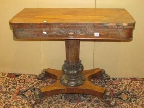 A Regency rose wood fold over top card table raised on an octagonal pillar with foliate column,