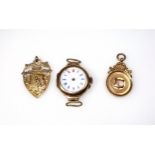 Two 9ct gold medals, 10.3grs, and a 9ct cased watch, Dia.26mm, case back 1.7grs, (a/f). (3)