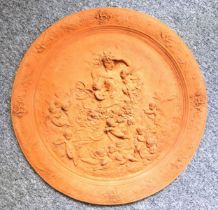 A terracotta plaque or roundel depicting a classical scene, 58cm diameter.