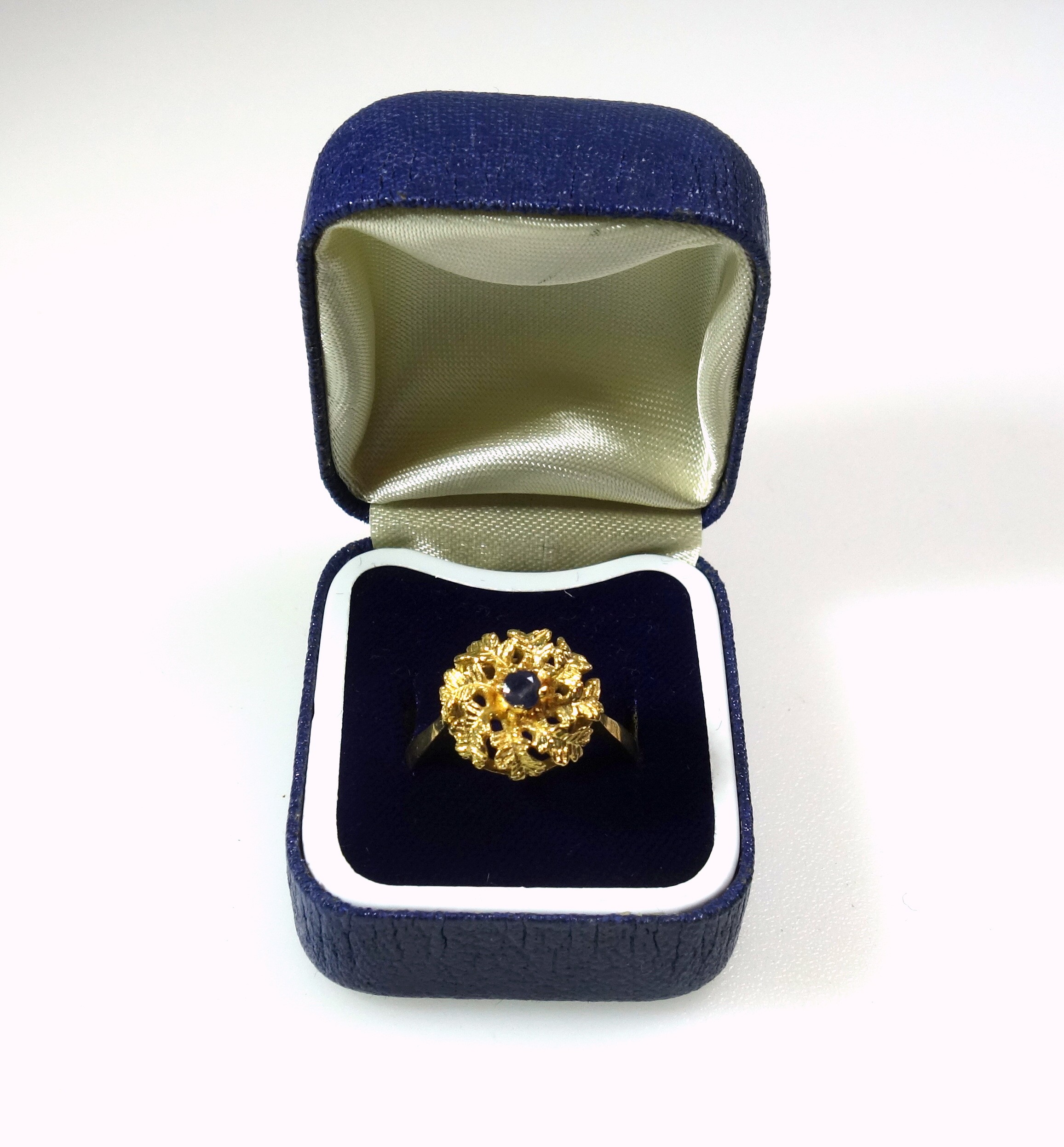 Foreign yellow metal ring with a sapphire in a floral setting, stamped 18k, 5grs, cased. (2)