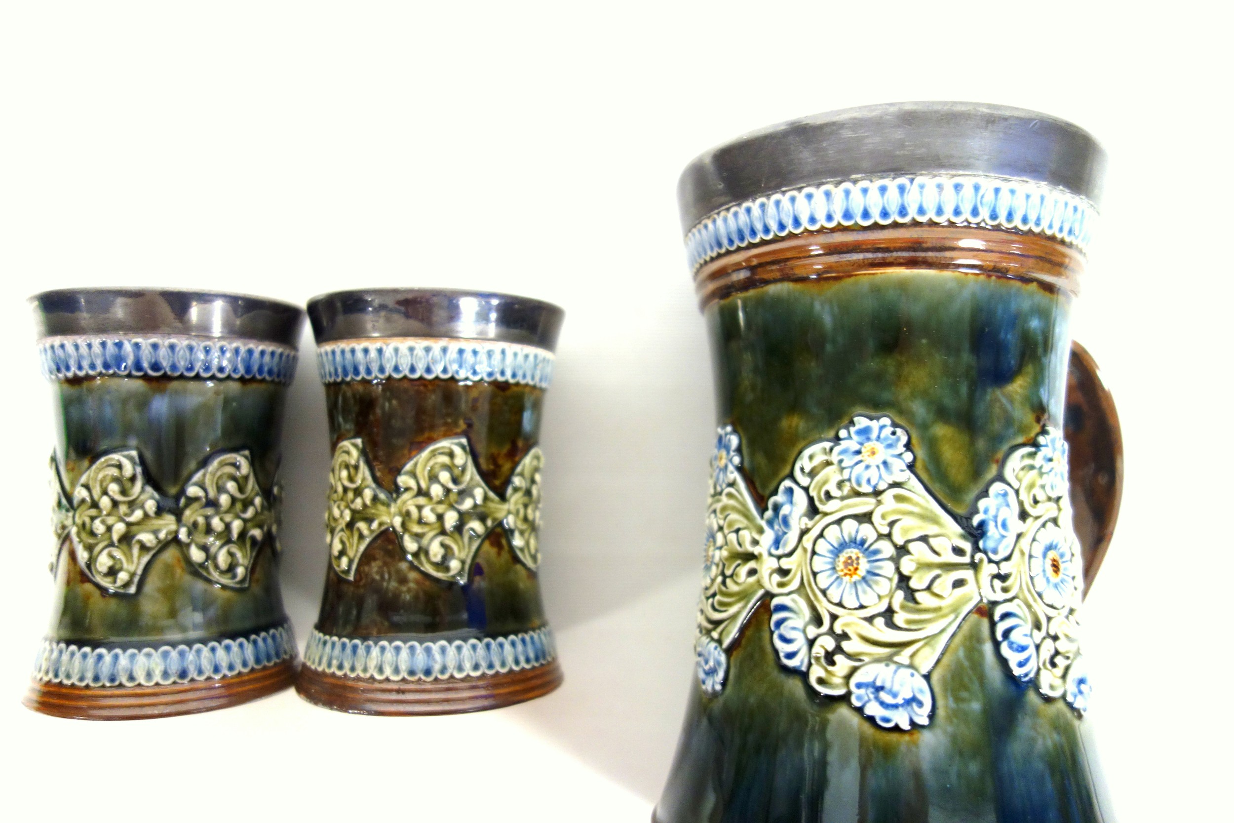 Royal Doulton Lambeth stoneware ale jug and two beakers, circa 1920, each with white metal rims, the - Image 3 of 3