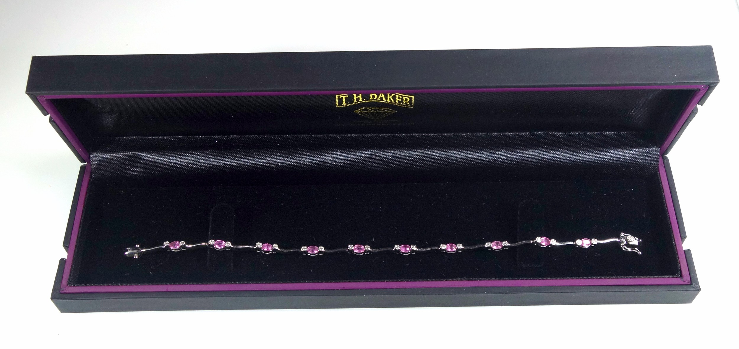 18ct white gold bracelet set with 20 brilliants and pale pink stones, L.18.5cm, gross 7.7grs, cased.