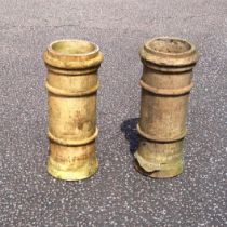 Pair of teracotta cylindrical chimney pots with ringed bands, H.65.5cm, (defects). (2)