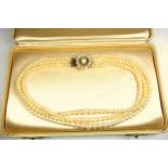 Triple row graduated cultured pearl necklace, L.39.5cm, with a 9ct gold pearl set floral clasp, L.