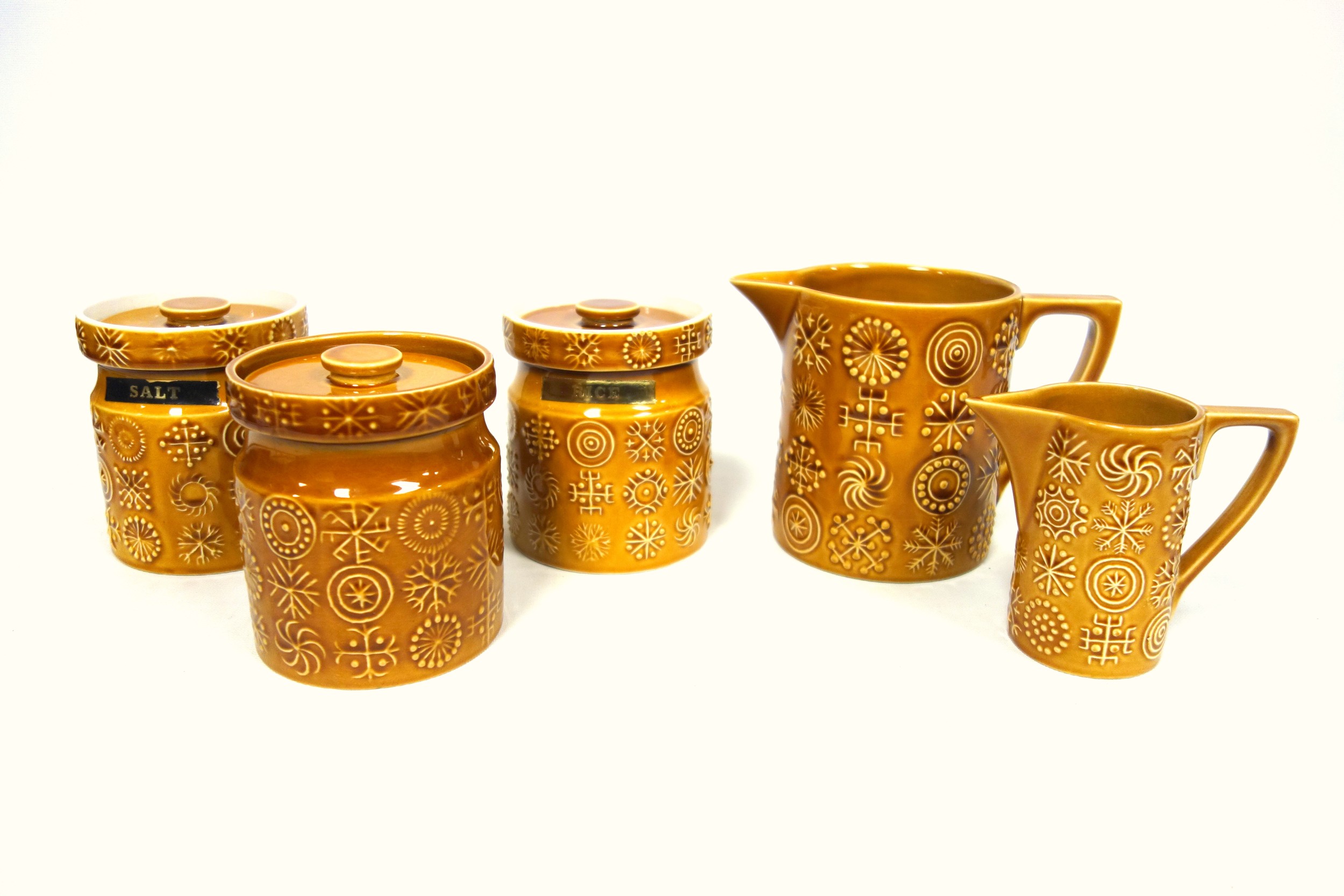 Portmeirion 'Totem' pattern; two matching storage jars with covers, 11cm high, in a mustard coloured